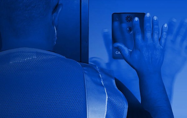 Pessoa acionando um dispositivo HUBBCOM da GAI-Tronics por aproximação da mão